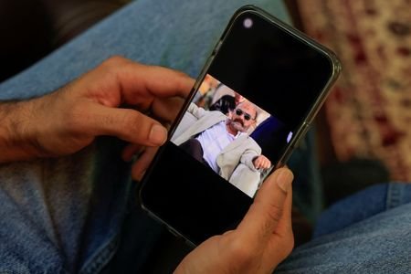 Yashib Rizwan, 33, holds a mobile phone showing a picture
