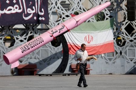 FILE PHOTO: A man walks next to a symbolic mockup