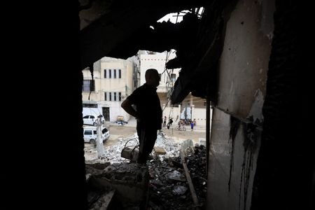 Palestinians inspect the site of an Israeli strike on a