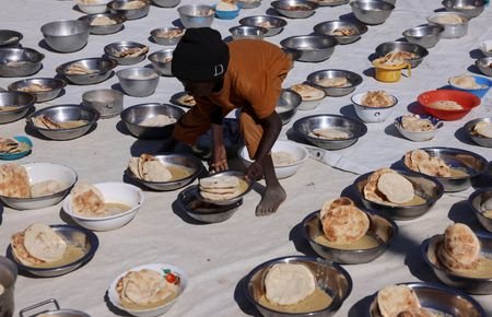 Sudanese refugees from al-Fashir receive free meals at the Tine