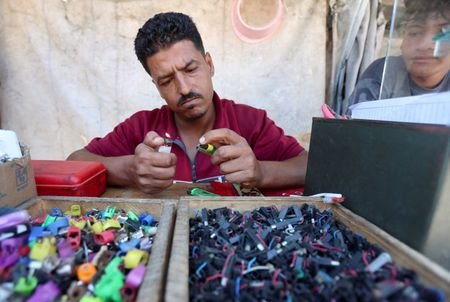 Palestinian lighter repairman Hassan Abu Latifa ignites a repaired lighter