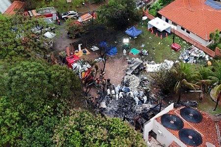FILE PHOTO: Officials work at the site of a plane