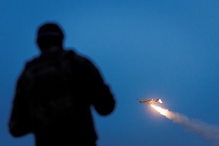 Ukrainian serviceman looks at an FP-1 deep-strike drone as it