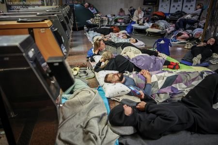 People take shelter inside a metro station during a Russian
