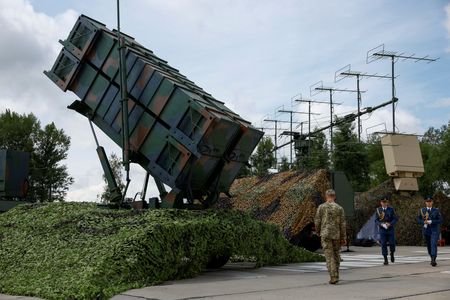 FILE PHOTO: Ukrainian service members walk next to a launcher