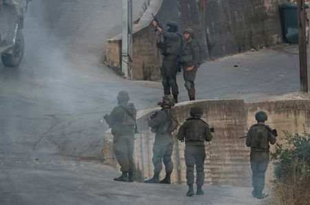 Israeli settlers approach the Palestinian village of Tal