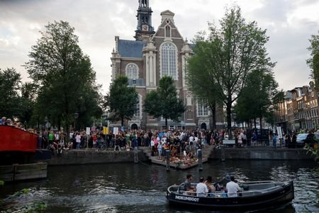 FILE PHOTO: People attend a memorial service at Amsterdam's Homomonument