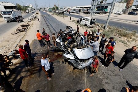 Palestinians inspect the site of an Israeli strike on a