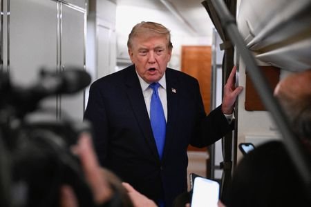 U.S. President Donald Trump speaks to the meadia aboard Air
