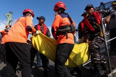 Rescue team members carry the body of a victim of