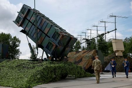 FILE PHOTO: Ukrainian service members walk next to a launcher