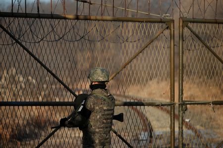 A South Korean soldier stands guard next to the rails