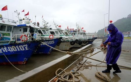 Crew member secures a boat at Nanyue Pier as Typhoon