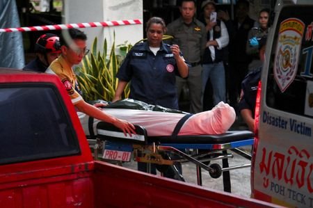 Emergency personnel carry the body of one of the grandparents
