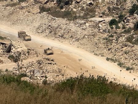 Israeli vehicles drive on a road in southern Lebanon, as