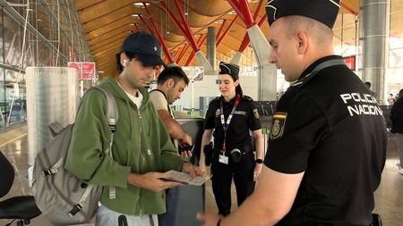 Spanish police check documents of travellers from Italy amid a