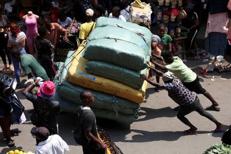 FILE PHOTO: People push a cargo cart through Balogun Market