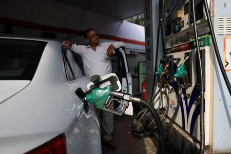 A man checks the fuel dispenser display as his car