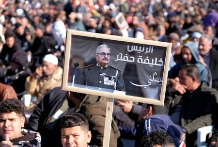 FILE PHOTO: A man holds a picture of commander Khalifa