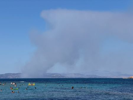 Smoke rises in Salamina as seen from Agistri island
