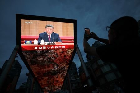 Giant screen shows Chinese President Xi Jinping delivering a speech