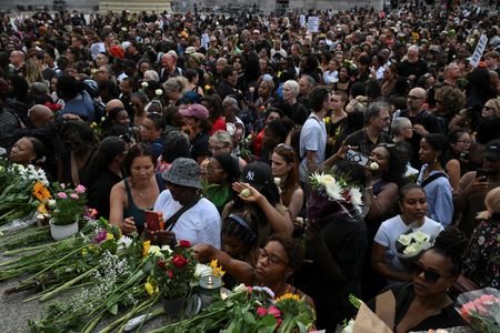 People attend a vigil to remember former Cambridge professor Jason
