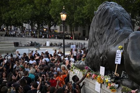People attend a vigil to remember former Cambridge professor Jason