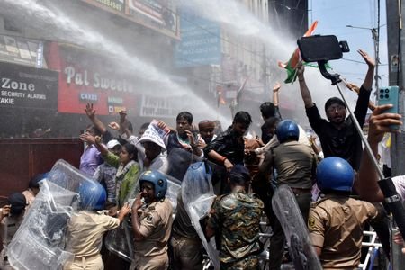 Students gesture as police use water cannons to disperse them
