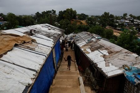 A Rohingya refugee child runs down the stairs of a