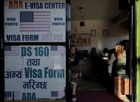 A woman holding a child sits at a visa consultancy,