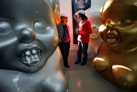 FILE PHOTO: Chinese artists the Gao Brothers walk past some