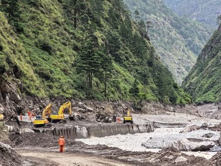 Rescue workers repair a damaged road leading to Gyirong Port