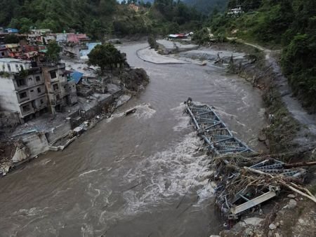 A drone view of a broken bridge and damaged houses