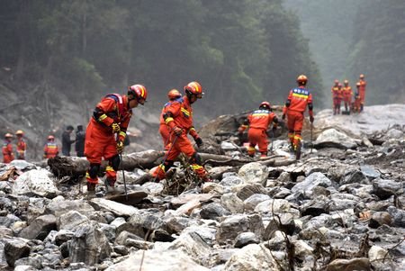 Firefighters conduct search and rescue operations along a river, after