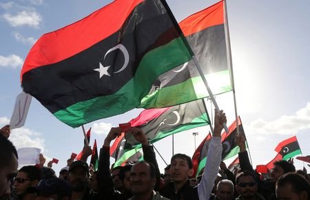 FILE PHOTO: People wave Libyan flags during a demonstration in