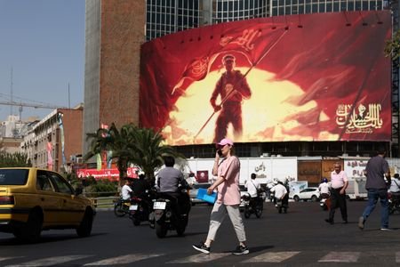 A woman walks on a street in Tehran