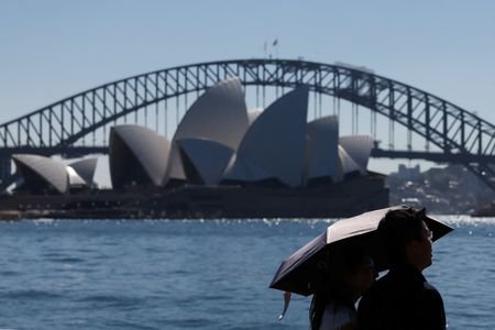 People shelter under an umbrella as they walk along the