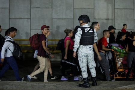 Migrants walk in a caravan bound for the northern border
