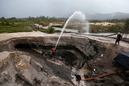 Miners dig with pressure hoses near the town of Ikabaru