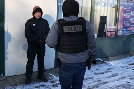 Federal agents question a man, during immigration removal operations in