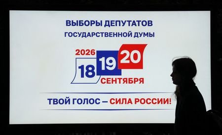 FILE PHOTO: A woman walks past a screen announcing Russia's