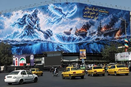 People drive past a billboard about the Strait of Hormuz,