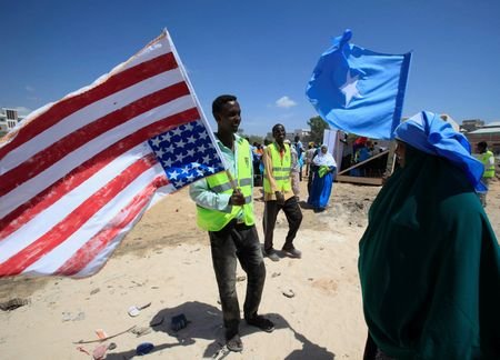 FILE PHOTO: A man holds on to a American flag