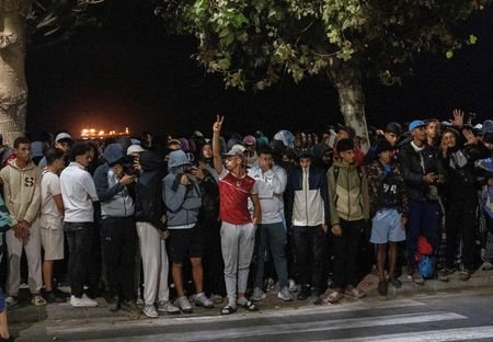 Police escort migrants from Benitez Beach to be relocated to
