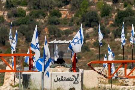 Israeli forces block a checkpoint after a shooting attack, near