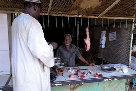 A resident stands in front of a butcher shop in