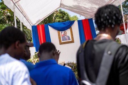 People line up to sign a condolence book in honour