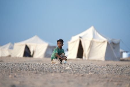 Boy sits at camp for internally displaced people near Aden