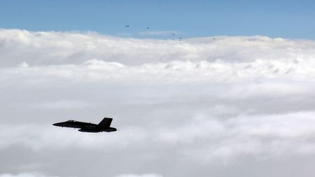 Finnish F/A-18 Hornet and Russian military aircraft fly over the