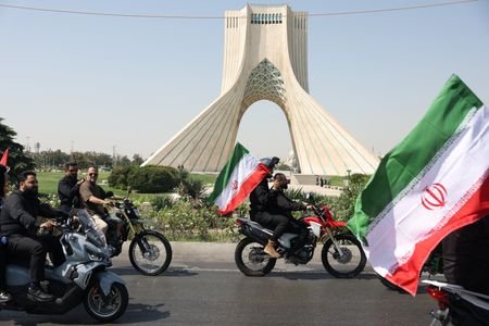 Members of Iranian militia forces (Basij) ride on motorcycles as